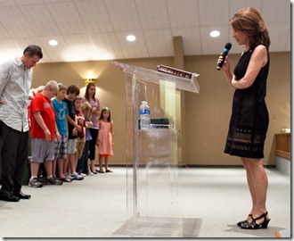 Bachmann prays, pic by Brendan Hoffman