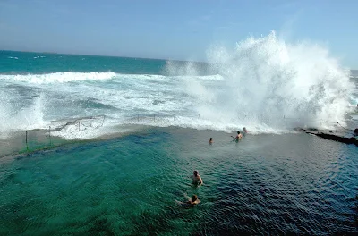 A wave crashes on the Bogey Hole ocean bath in Newcastle, Hunter, North Coast NSW, Australia.