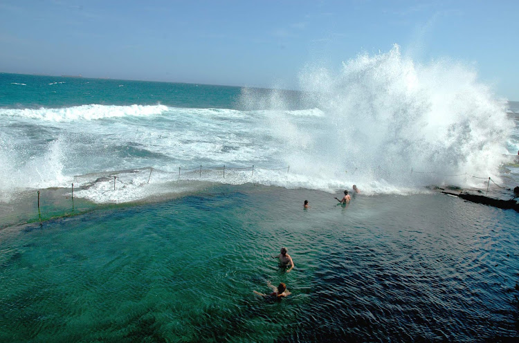 A wave crashes on the Bogey Hole ocean bath in Newcastle, Hunter, North Coast NSW, Australia.