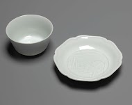 Klokvormige kop en schotel met twee hazen en de maan in reliëf