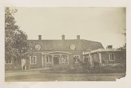 Huis met een veranda en een voortuin met een zonnewijzer