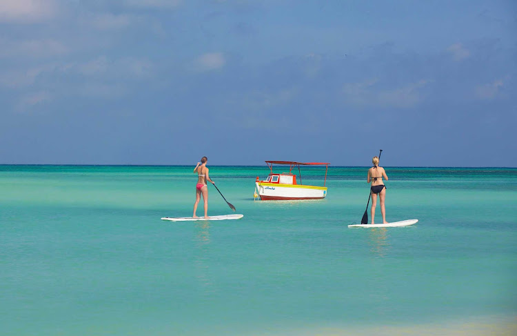 Two women on stand-up paddleboards in Aruba.