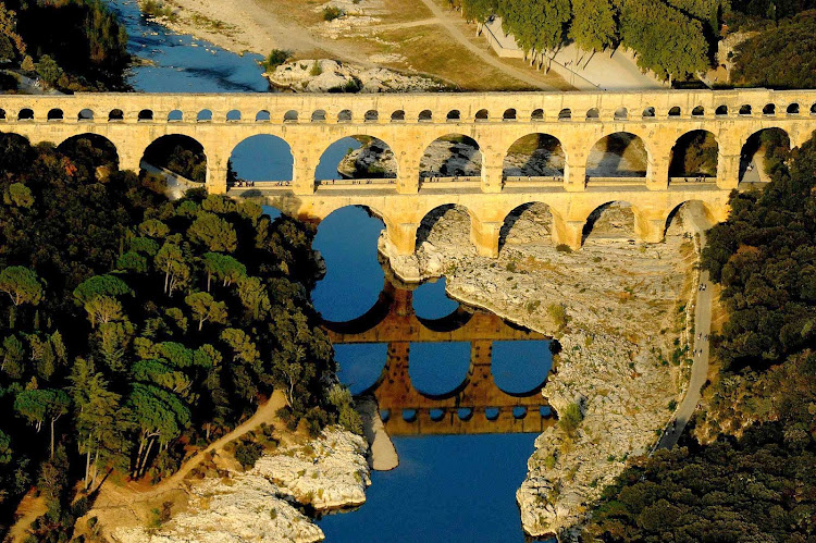 The ancient Roman aqueduct bridge, Pont du Gard, crossing the Gardon River in the Languedoc-Roussillon region of southern France. 