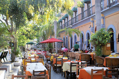 A row of outdoor restaurants alongside a park in Mazatlan, Mexico.