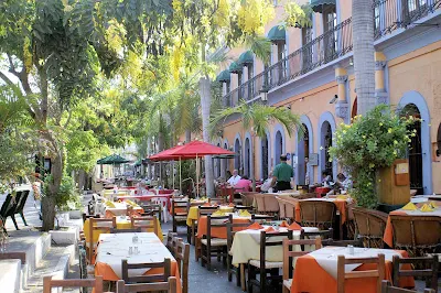 A row of outdoor restaurants alongside a park in Mazatlan, Mexico.