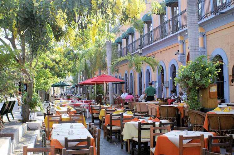 A row of outdoor restaurants alongside a park in Mazatlan, Mexico.