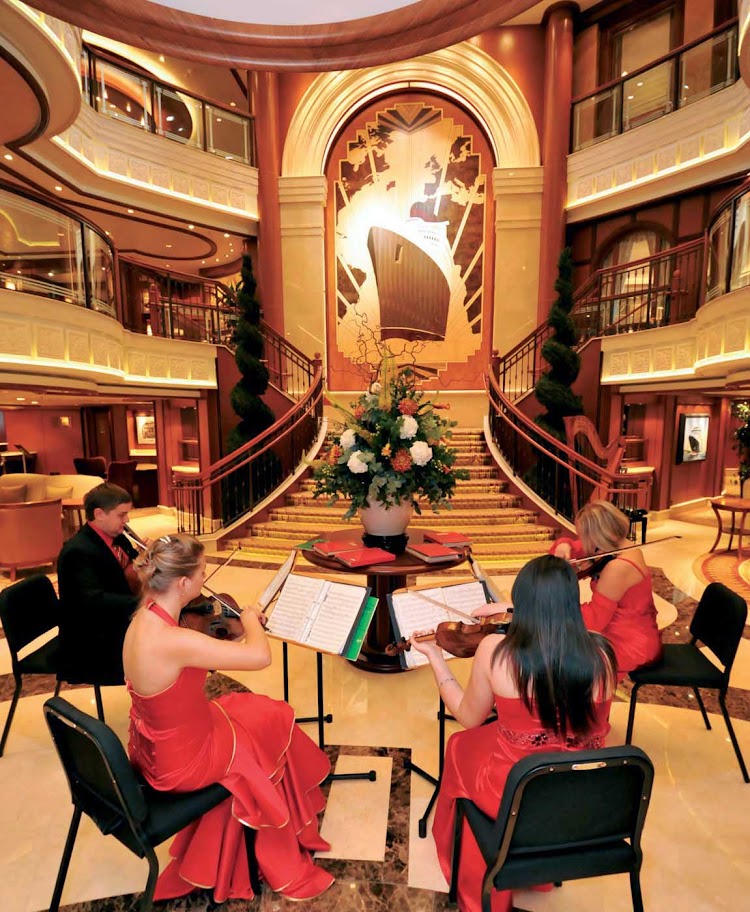 A string quartet performs in the Grand Lobby of the Queen Elizabeth, which reaches three decks high. 
