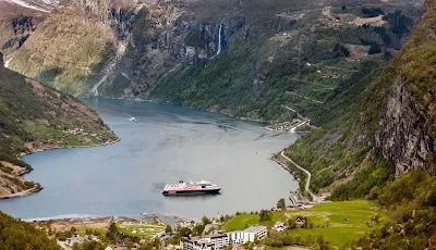 Travel to the UNESCO-protected fjord Geirangerfjord in Norway on board Hurtigruten's ms Midnatsol and experience spectacular views of snow-covered mountain ranges, waterfalls and abandoned farms.