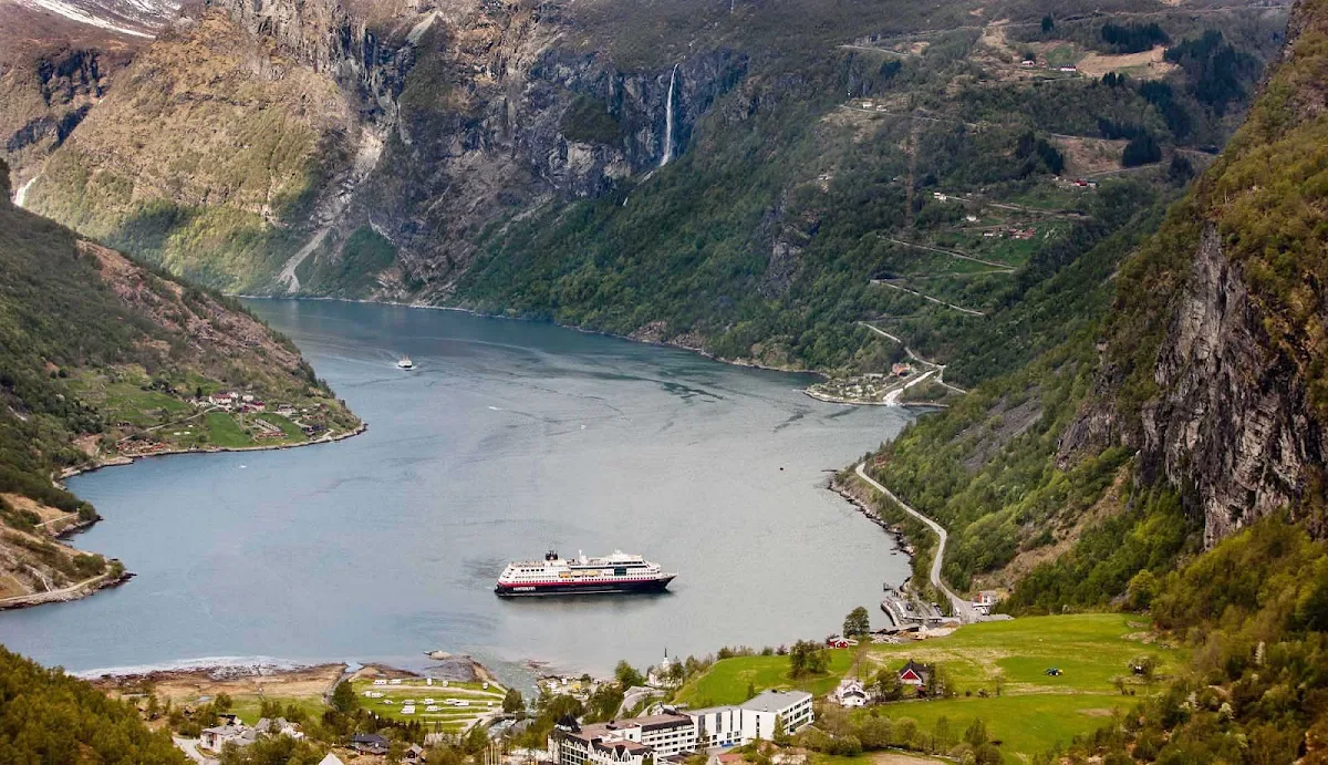 Hurtigruten-Midnatsol-in-Geirangerfjord - Travel to the UNESCO-protected fjord Geirangerfjord in Norway on board Hurtigruten's ms Midnatsol and experience spectacular views of snow-covered mountain ranges, waterfalls and abandoned farms.
