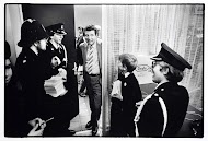 EO-leden in politie-uniform staan klaar om wervingsbonnen uit te delen