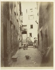 Een nauwe straat in Menton met vrouwen en kinderen in het straatbeeld