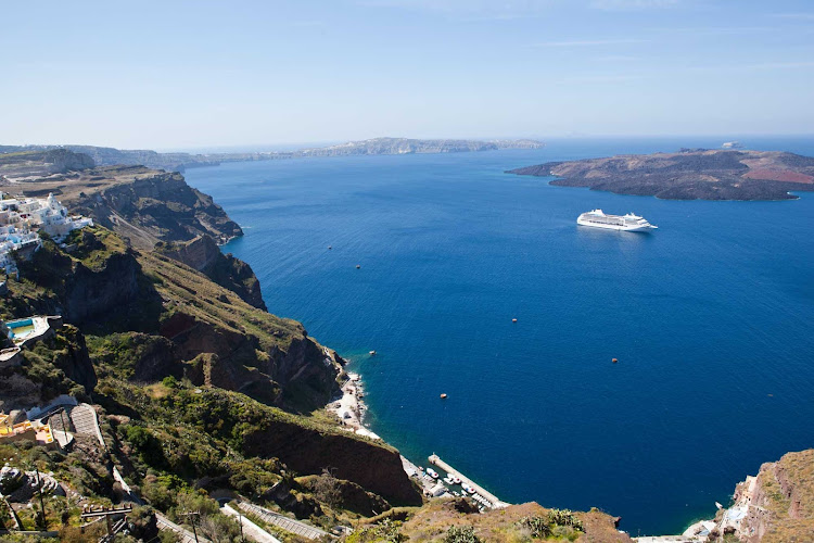 Behold dramatic cliffs and the glimmering Aegean Sea from the hilltop capital of Fira during a cruise to Santorini and other Greek islands aboard Seven Seas Mariner.