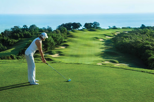 Jamaica-golf-course - Seeing green: A woman is about to tee off on a golf course hugging the Jamaican coast. 