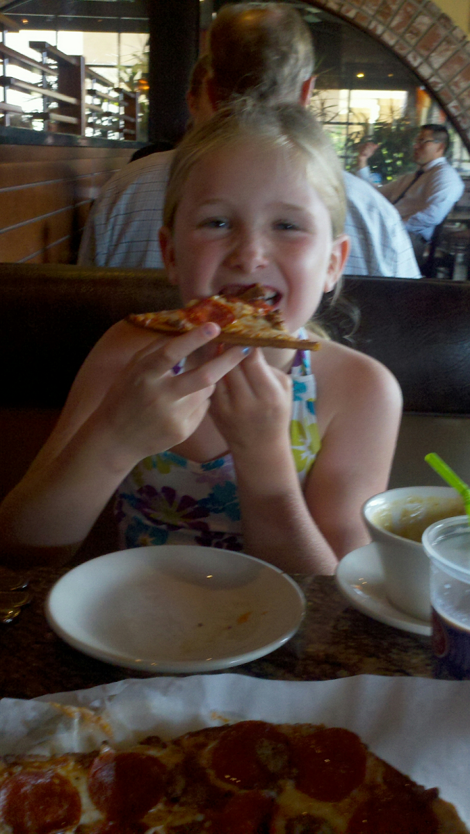 My daughter eating the delicious gluten free pizza at BJs restaurant.