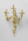 Wandarm van verguld brons met drie uit asymmetrische C- en S-voluten opgebouwde armen.
