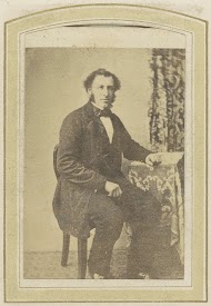 Portret van een zittende man bij een tafel