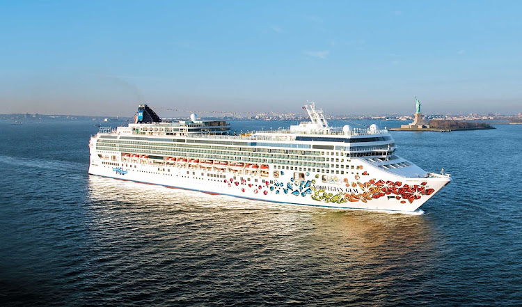 Norwegian Gem sails past the Statue of Liberty into New York Harbor.