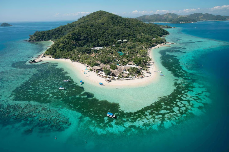 Pleasure craft form a ring around an islet resort in Fiji. 