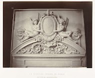 Reliëf boven de deurpost waar mannelijke engelen naast een medaillon en boven ornamenten zijn geplaatst.