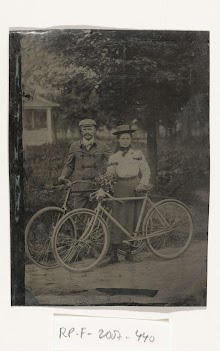 Een man en vrouw staand bij hun fietsen in de openlucht, met een bosje bloemen