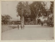 Straatbeeld in Nederlands-Indië met kinderen, dragers en voorbijgangers