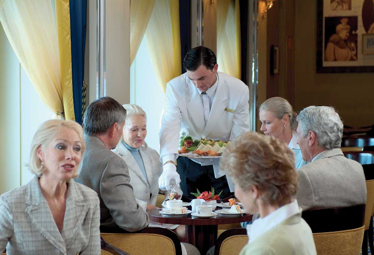 Enjoy being served by white-gloved waiters during afternoon tea while listening to a live orchestra in the Queens Room aboard Queen Mary 2.