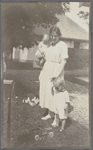 Tine Kleiterp-Vermeulen en haar kinderen Klaas en Tiny op een grasveld in Madje op Celebes