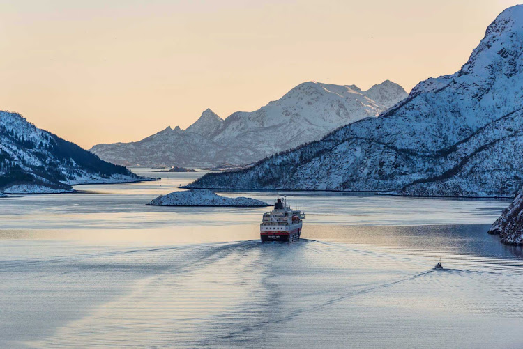 Hurtigruten's expedition ship Richard With sails down the Raftsundet strait in Nordland, Norway, into a winter sunset. 