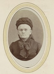 Portret van een vrouw met een hoofddeksel en een bril