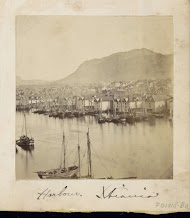 Gezicht op schepen en pakhuizen in de haven van Christiania met op de achtergrond bergen