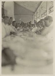 Mannen zittend aan een lange tafel