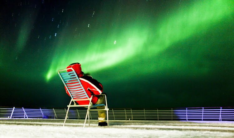 A guest pulls up a front row seat to the Northern Lights aboard a cruise on Hurtigruten's Finnmarken between the northern ports of Kirkenes and Tromsø.