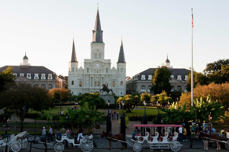 Horse-drawn carriages pull up to Jackson Square in New Orleans. 