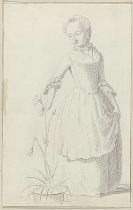 Staande vrouw plukt een bloem van een plant in een bloempot