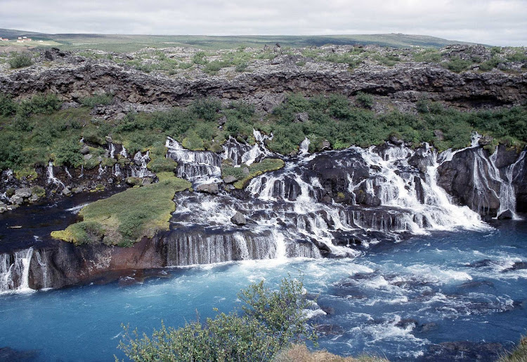 Hraunfossar is a series of waterfalls formed by rivulets streaming over rocks in Iceland.