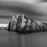 Shipwrecked in grayscale waters by Bill Peppas -  