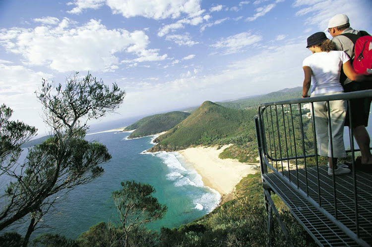 A couple at Tomaree Head lookout, overlooking Zenith Beach, Tomaree National Park, Port Stephens along Australia's North Coast NSW.