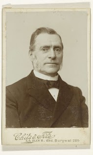 Portret van een oudere man in pak met een das voor