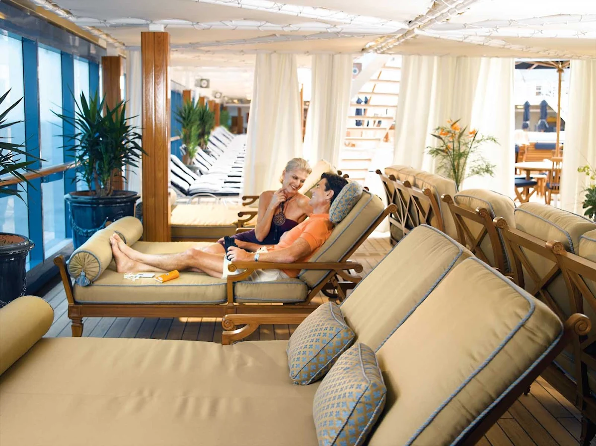 Oceania-Couple-on-Patio - Unwind and enjoy the serenity of Oceania Regatta's Patio lounge area while taking in the view.