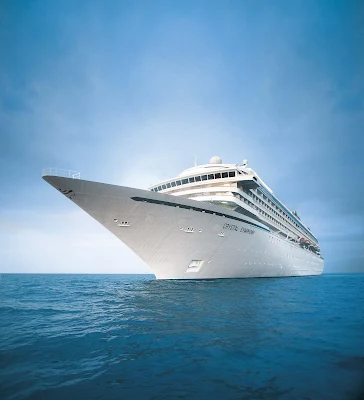 The Crystal Symphony sails out of the sunrise in crisp arctic waters.