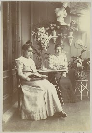 Twee vrouwen, zittend in een serre, één lezend