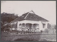 Twee vrouwen poserend bij de veranda van een woonhuis, vermoedelijk op het terrein van een ziekenhuis in Nederlands-Indië