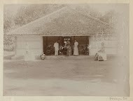 Nederlanders voor een huis met Boeddhabeelden in Nederlands-Indië