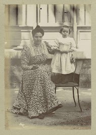 Portret van een zittende vrouw met een kind staand op een stoel