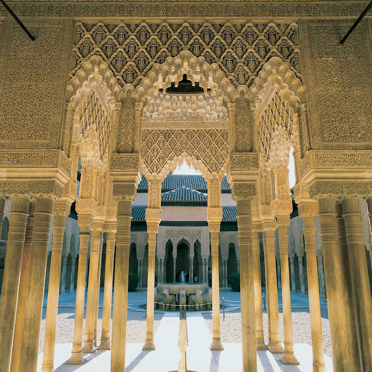 Patio de los Leones, part of the fortress and palace complex of Alahambra in Granada, Spain, has beautiful fountains and an ornate structural design.