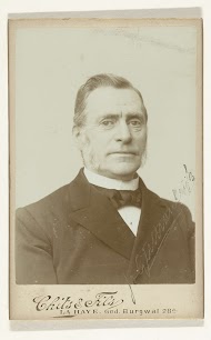 Portret van een oudere man in pak met een das voor