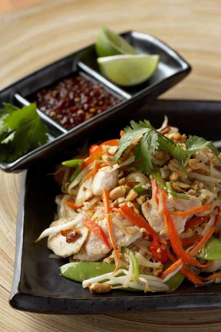 Pad Thai accompanied by a garnish of lime, coriander and chilli served in the Celebrity Cruises restaurant Silk Harvest.