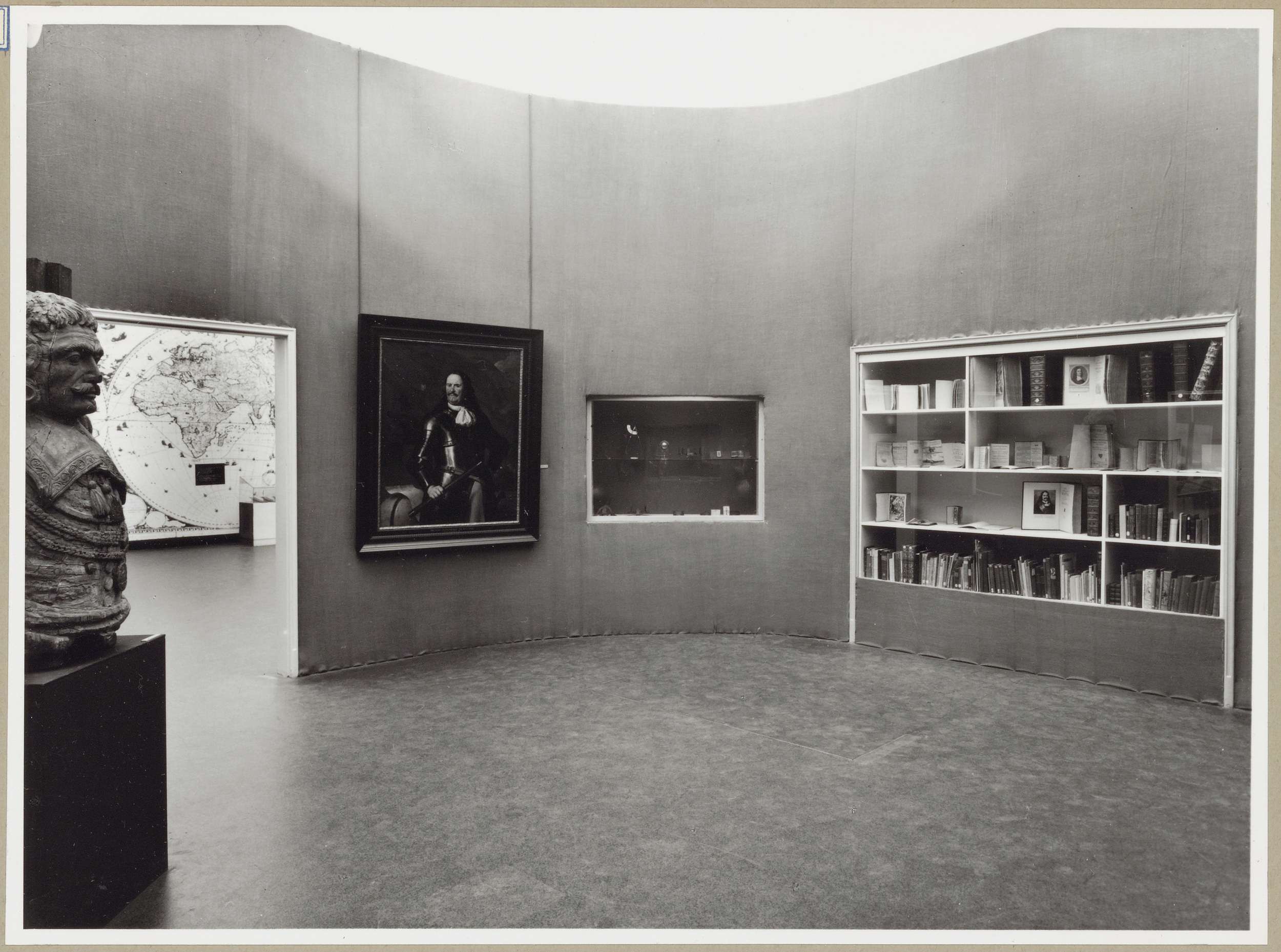 Zaal met een borstbeeld, een schilderij en twee vitrines in de muur rechts