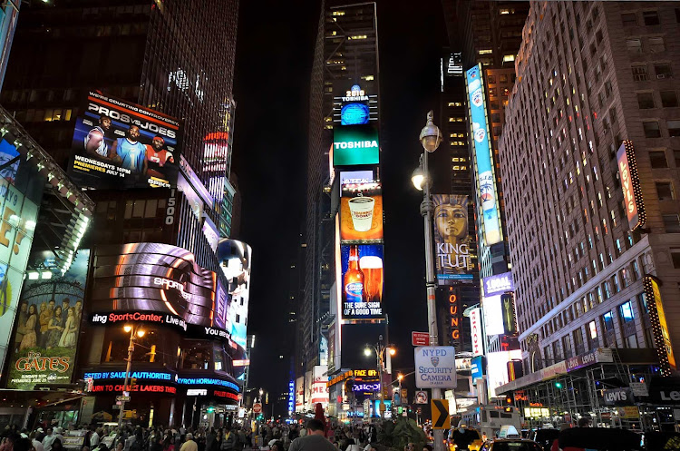 Times Square at night, soaked in neon billboards (multiple exposures). 