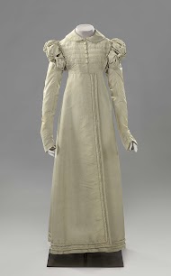 Redingote of jasjurk (a) van zijde oorspronkelijk changerend van blauw naar lila, maar sterk verkleurd  en spencer met ontbrekende mouwen (b) van dito zijde